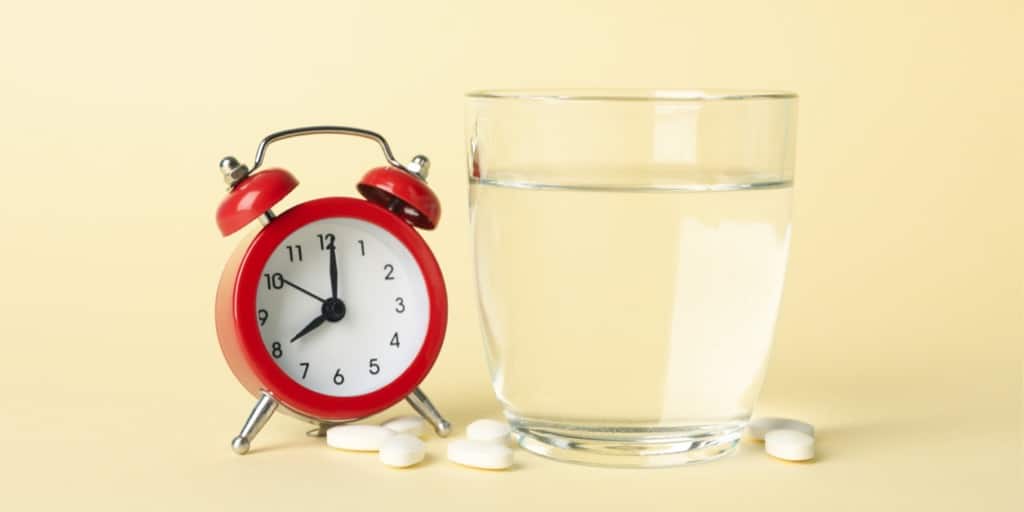 Hvornår er det bedst at tage vitaminpiller? Piller, vandglas og ur.